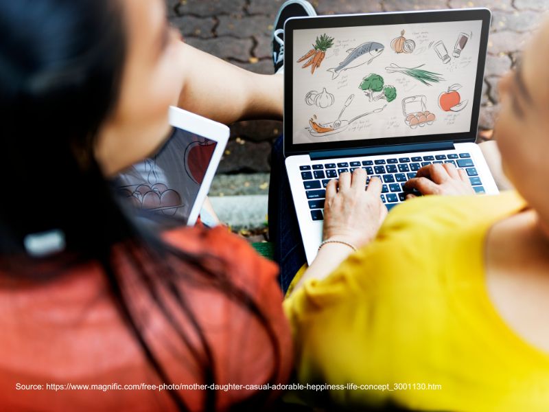 Woman and young girl using a laptop together, illustrating the Shopify vs WordPress comparison.